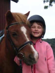 Shetland pony girl with pink fleece jacket