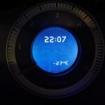 Car dashboard gauge showing time and temperature