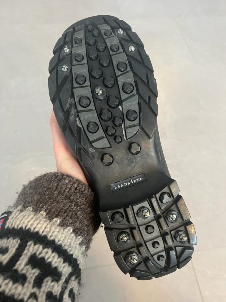 Sole of winter boot with studs screwed in